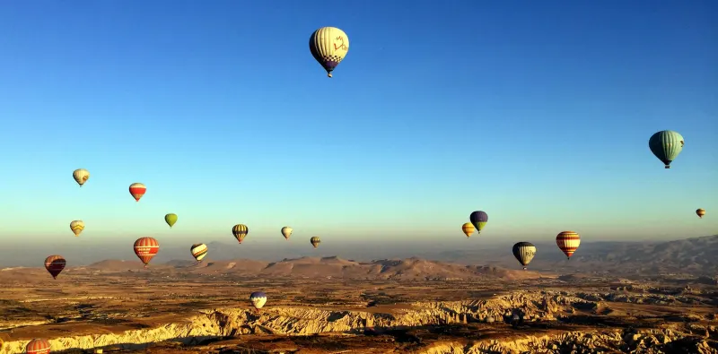 Hot air balloons over a valley at sunrise